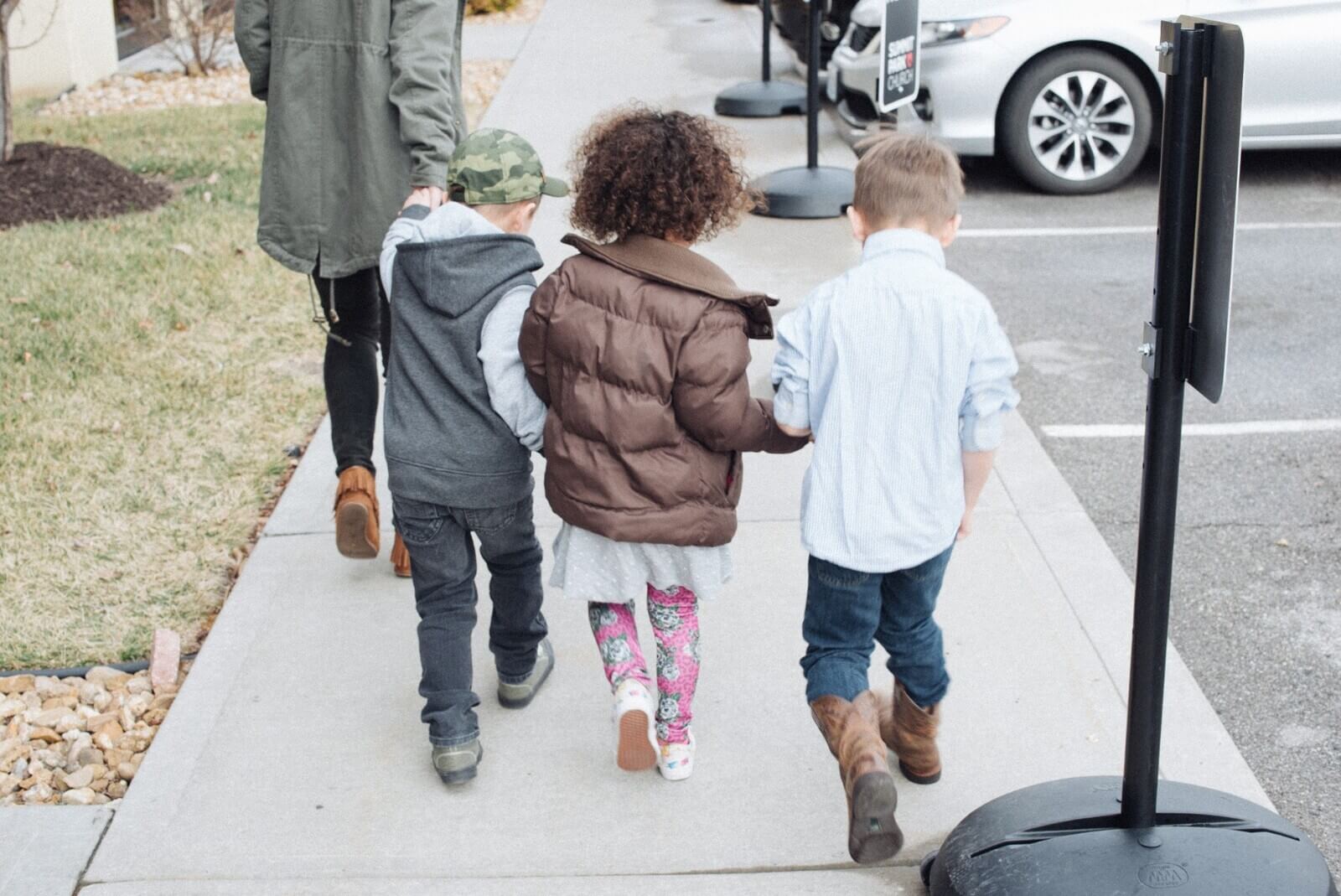 children of St. John's MCC walking on a sidewalk holding hands
